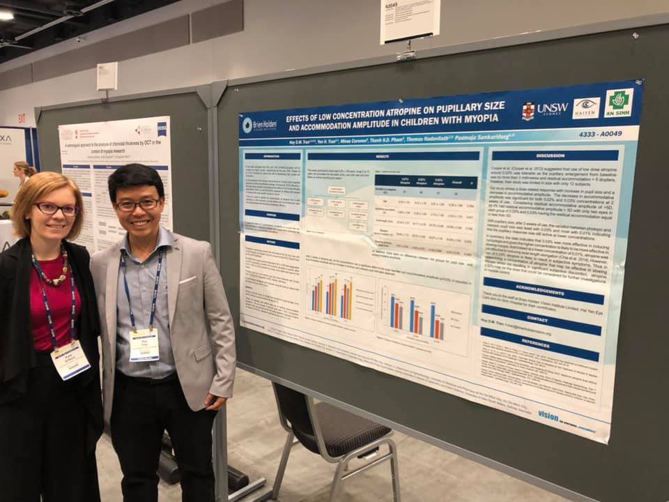 Trần Đình Minh Huy and Kate in front of his poster titled: Effects of Low Concentration Atropine on Pupillary Size and Accommodation Amplitude in Children with Myopia